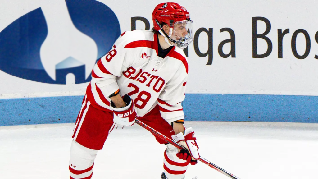 Boston University hockey player with Braga Bros banner/ad in background.